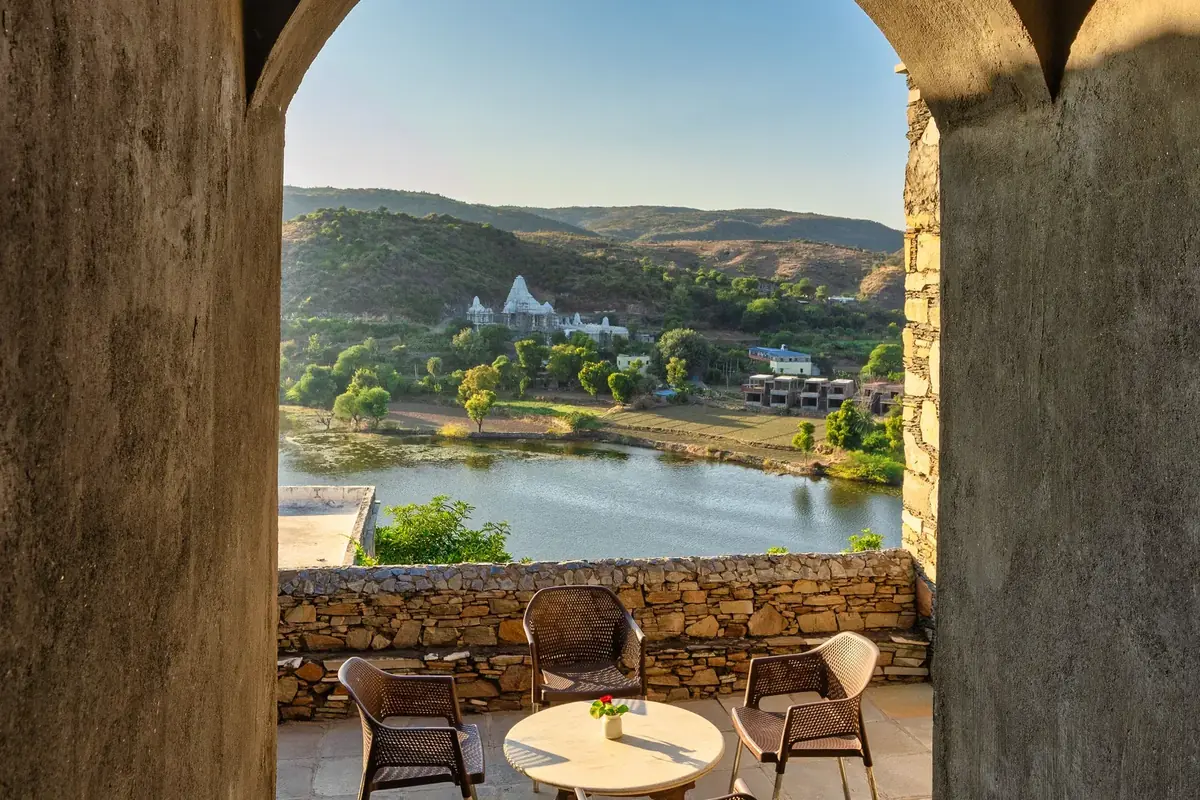 Arched terrace framing Bagela Lake and the Eklingji temple at sunrise