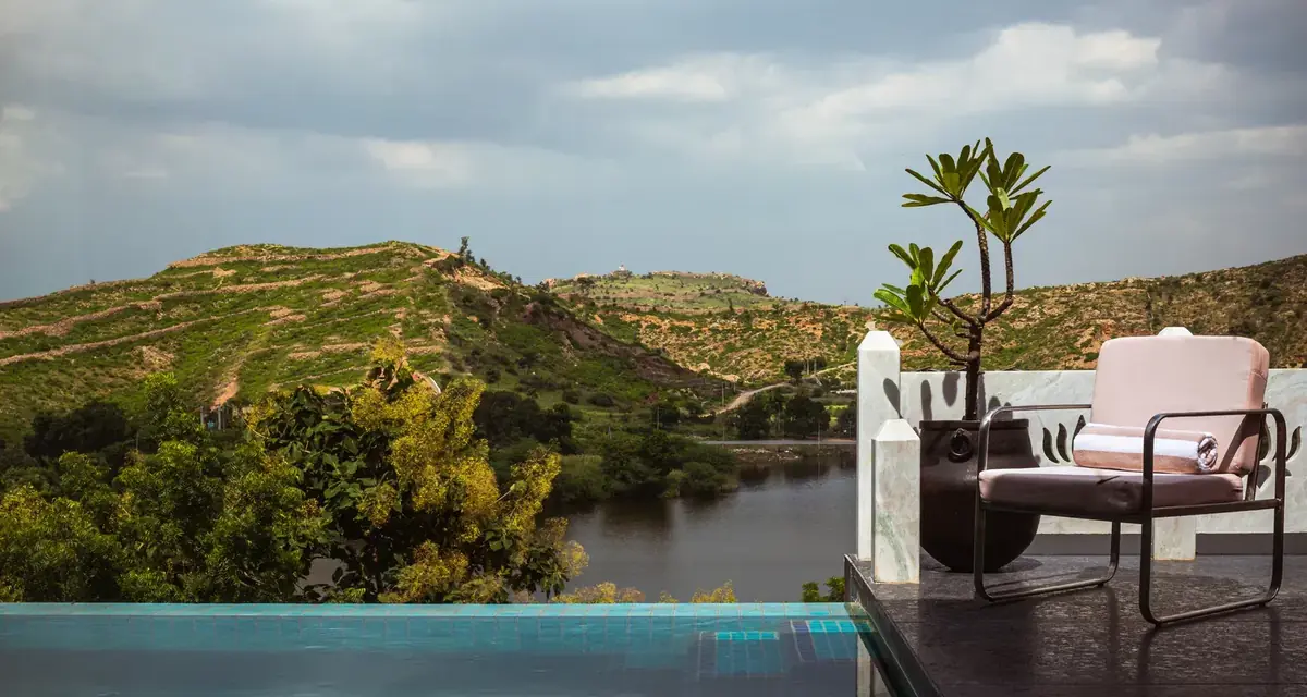 Infinity pool edge looking out over the lake and Aravalli hills