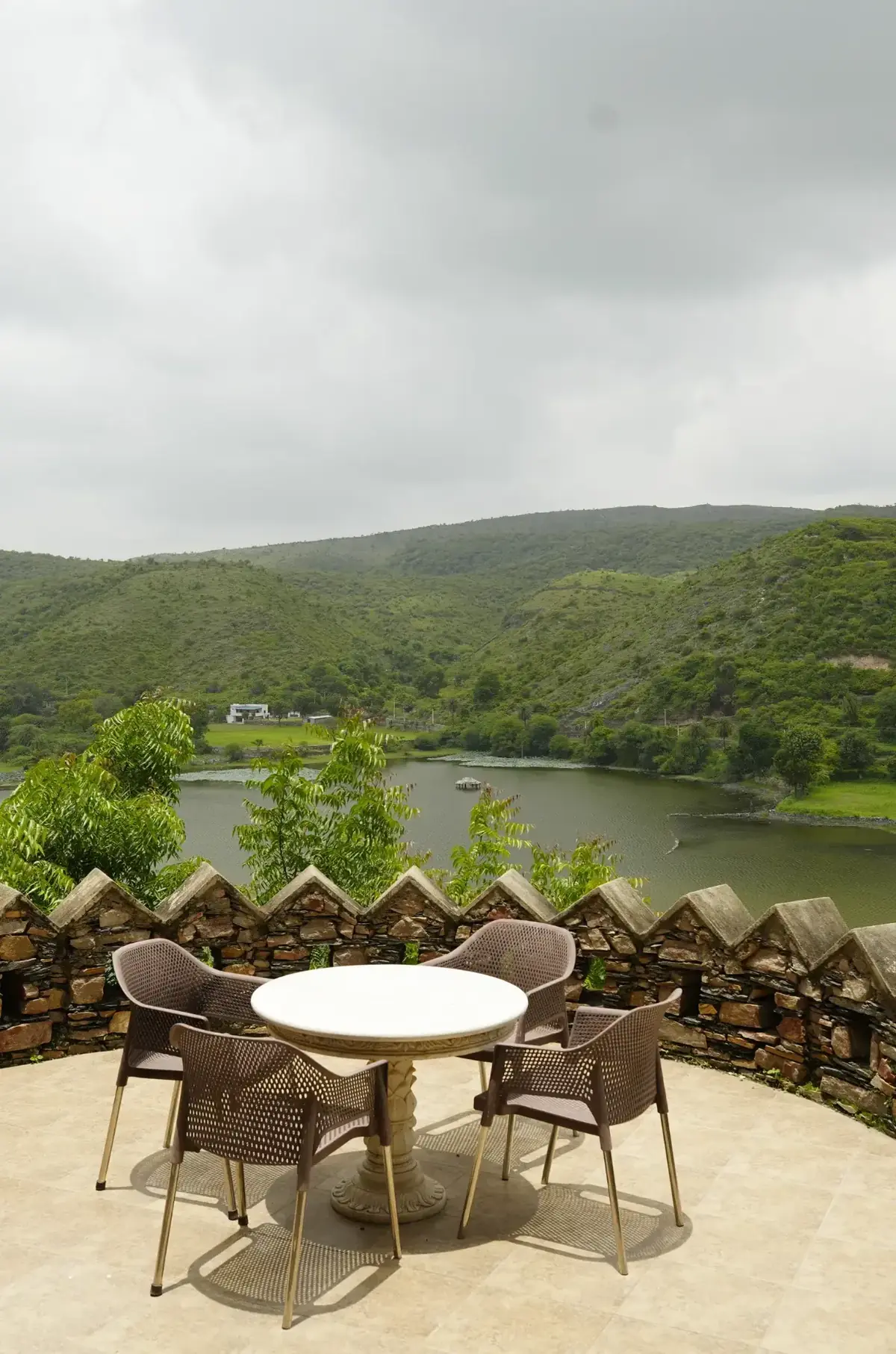 Private terrace table above the lake with monsoon-green hills