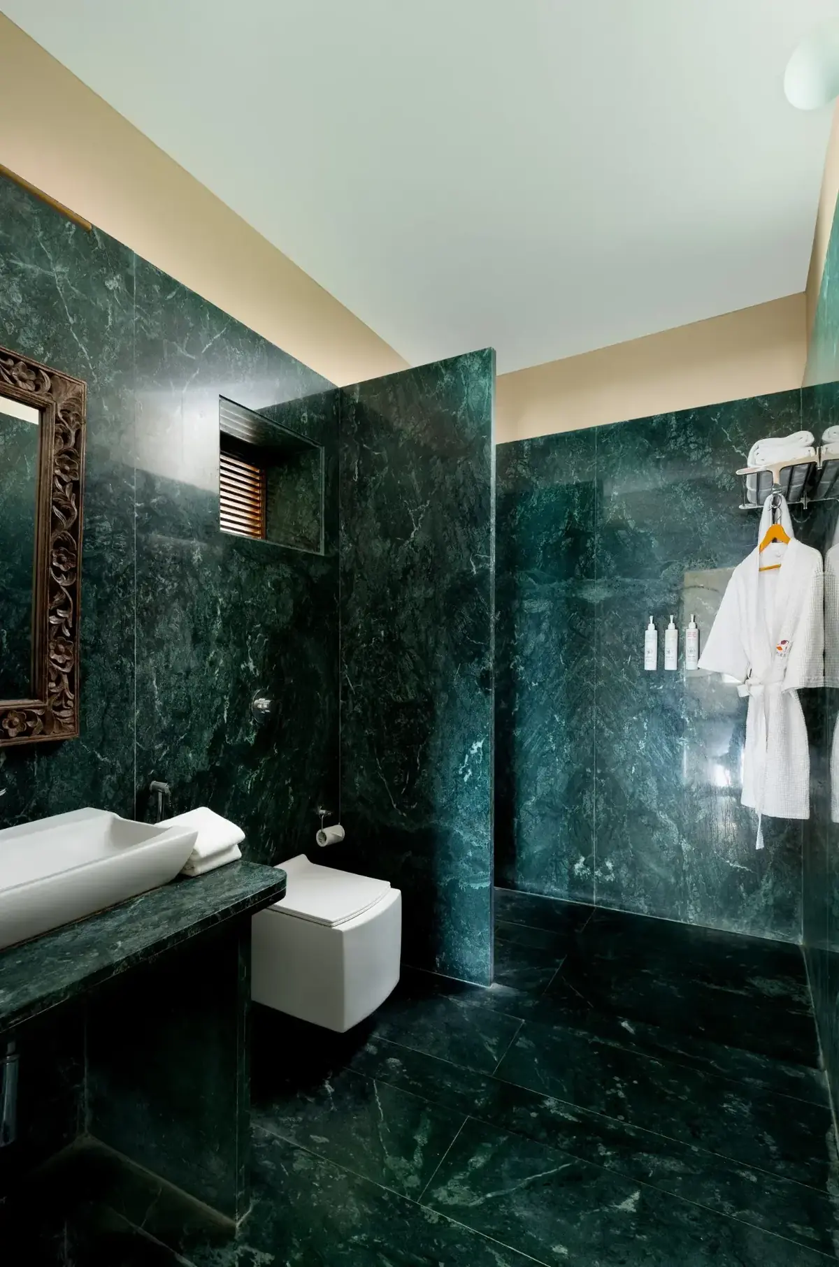 Green marble bathroom with rain shower and robes