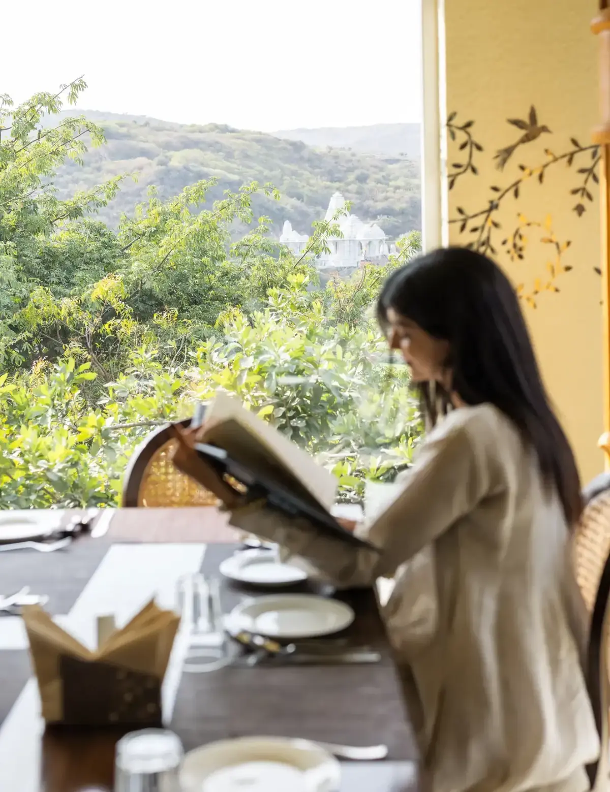 Guest enjoying a quiet morning overlooking the green hills at YAAN Udaipur