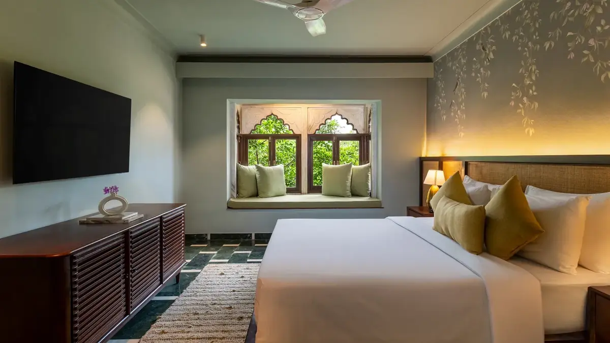 Elegant king room with a heritage arched window at YAAN Udaipur