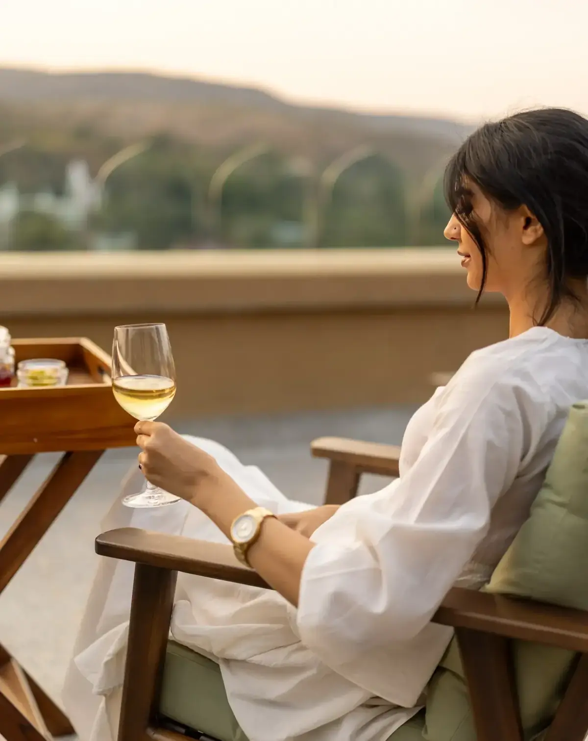 Guest relaxing with a drink on a sunset terrace